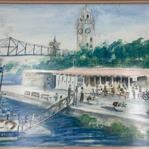 May include: Watercolor painting of a waterfront scene with a bridge, clock tower, and a ferry boat. The painting features a restaurant with people, bicycles, and a flag. The color palette includes blues, greens, and browns.