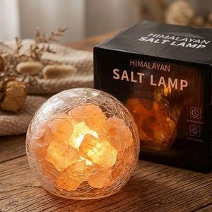 May include: A white ceramic mug with a black handle and the text "But First, Coffee" in a bold, black font. The mug is set against a neutral background, highlighting its simple design.