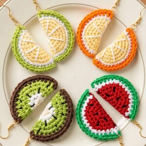 May include: Four pairs of handmade crochet fruit earrings featuring lime, orange, kiwi, and watermelon slices. Each earring is crafted with colorful yarn to mimic the texture of fruit segments and includes gold-toned metal fishhook ear wires.