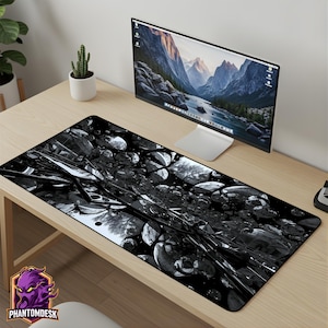 May include: A rectangular mousepad featuring a black and white abstract design with a geometric pattern. The mousepad is on a wooden desk, with a computer monitor and a small cactus in the background. The PhantomDesk logo is in the bottom left corner.