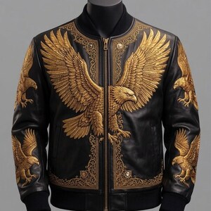 May include: A black leather bomber jacket featuring intricate gold embroidery of a large eagle across the chest and smaller eagles on each sleeve. The design includes ornate gold filigree patterns along the front zipper and collar area.