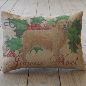 May include: A brown burlap pillow with a printed image of a golden retriever dog with holly and berries. The pillow has the text "Joyeux Noel" printed on it.
