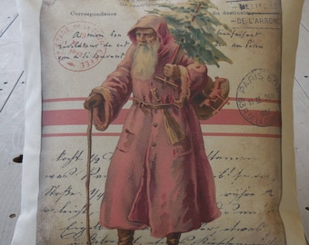 May include: A vintage Christmas pillow cover featuring a red-clad Santa Claus carrying a sack of gifts and a walking stick. The background is a cream-colored canvas with red stripes and French text. The text reads "Joyeux Noel" which means "Merry Christmas" in French.