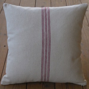 May include: A white linen pillow with three red stripes down the center.
