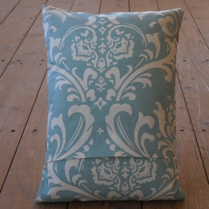 May include: A blue and white patterned pillow with a damask design. The pillow has a hidden zipper closure on the back.