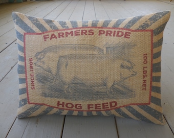 May include: A tan and blue striped pillow with a red and white graphic of a pig and the text "Farmers Pride Since 1805 Hog Feed 100 LBS. NET".
