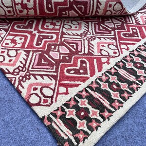 Red geometric wool rug with black cream accents and detailed handmade design