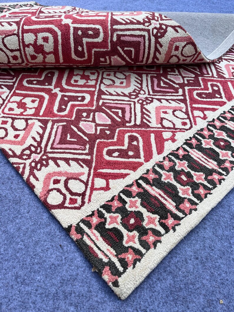 Red geometric wool rug with black cream accents and detailed handmade design