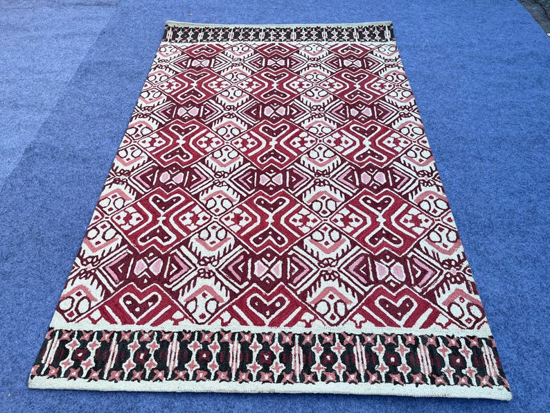 Burgundy wool area rug with detailed geometric pattern and contrasting cream motifs