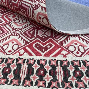 Statement living room rug with burgundy geometric pattern and dark decorative border