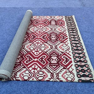 Hand tufted wool carpet with burgundy geometric motifs and cream detailing
