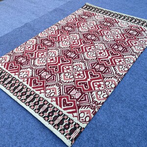 Handmade red black cream rug with intricate geometric and ornamental design