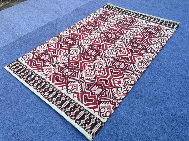 Handmade red black cream rug with intricate geometric and ornamental design