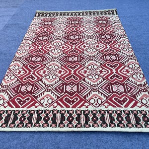 Hand tufted wool area rug with burgundy black and ivory geometric design
