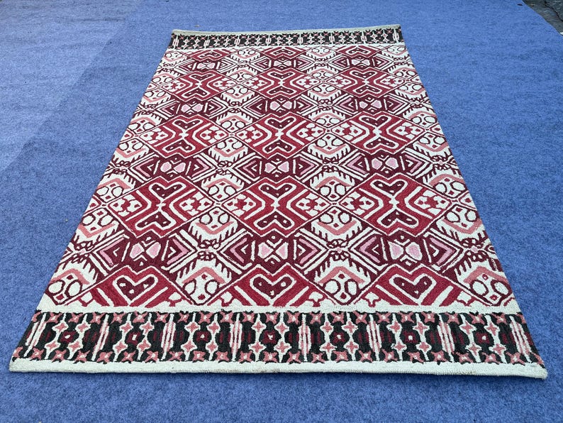 Hand tufted wool area rug with burgundy black and ivory geometric design