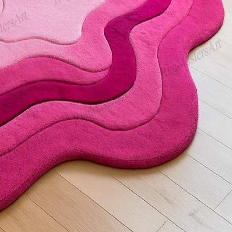 Soft pink hand tufted contour rug with abstract layered wave pattern, funky irregular shape area rug for modern living room, cute bedroom decor and stylish feminine interior design.