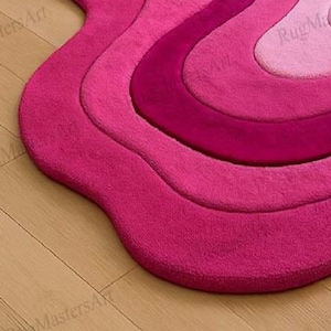 Close-up of vibrant pink abstract tufted rug with flowing wave design, irregular shaped fluffy carpet, modern statement area rug for stylish bedroom, chic apartment and contemporary home interior.
