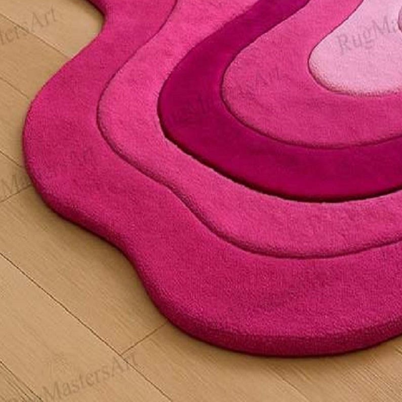 Close-up of vibrant pink abstract tufted rug with flowing wave design, irregular shaped fluffy carpet, modern statement area rug for stylish bedroom, chic apartment and contemporary home interior.