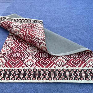 Geometric wool rug with deep red black and ivory color palette for modern interiors