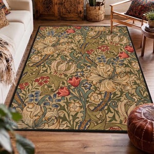 May include: A rectangular area rug featuring a dense botanical pattern with large cream-colored lilies, red tulips, and small blue flowers intertwined with swirling green acanthus leaves on a light tan background, finished with a thin black border.
