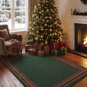 May include: A rectangular area rug featuring a solid dark green center with a decorative border consisting of red, gold, and dark green plaid patterns. The rug is positioned on a wooden floor in a room with a Christmas tree and a fireplace.
