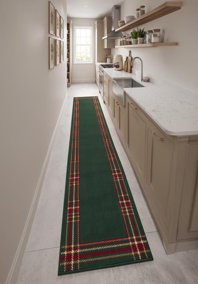 May include: A long rectangular runner rug featuring a solid dark green center panel framed by a decorative border. The border consists of a red and gold plaid pattern with thin intersecting lines, creating a classic tartan-inspired design.