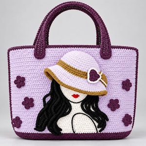 May include: A light purple crochet handbag featuring a dark purple base and handles. The front displays a crocheted applique of a figure with long black hair, red lips, and a light purple sun hat with a brown band and a dark purple heart accent.