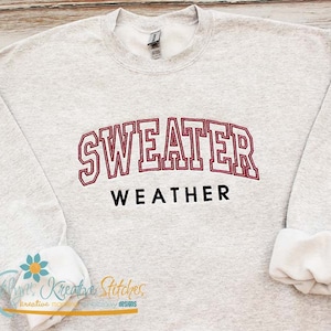 May include: A gray sweatshirt with the text "SWEATER WEATHER" in red and black lettering.