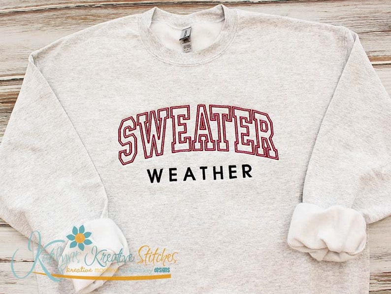May include: A gray sweatshirt with the text "SWEATER WEATHER" in red and black lettering.