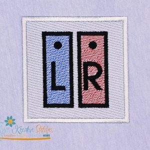 Op de afbeelding: Geborduurde patch met twee verticale rechthoeken. De linker rechthoek is blauw met een zwarte rand en de letter "L". De rechter rechthoek is rood met een zwarte rand en de letter "R". Beide rechthoeken hebben een zwarte stip aan de bovenkant.