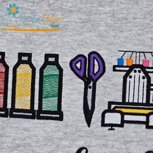 May include: Embroidered design featuring spools of thread in red, yellow, and green, purple scissors, and a sewing machine. The design is on a gray background. The text "Kreative Stitches" is at the top.
