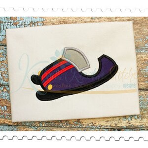 May include: An embroidered design of a purple and black hat with red stripes and a silver brim. The hat has a yellow button and is set against a white background. The design is likely for machine embroidery.