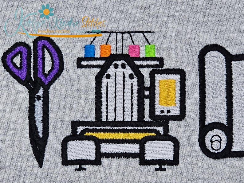 May include: Embroidered design featuring sewing tools and equipment. Includes scissors with purple handles, a sewing machine with colorful thread spools, and a roll of fabric. The design is on a gray background.
