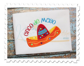 May include: White t-shirt with an embroidered design of a sombrero and the text "Cinco de Mayo".