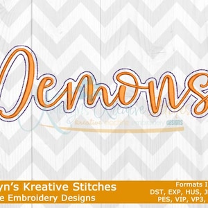 Op de afbeelding: Oranje borduurontwerp van het woord "Demons" in een cursief lettertype. Het ontwerp is omlijnd met paars en is geschikt voor machineborduren.