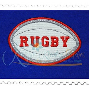 May include: A white rugby ball with red stitching and the word "RUGBY" in red letters.