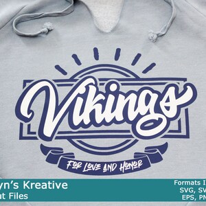 Peut inclure: Un sweat-shirt gris avec un motif graphique bleu marine et blanc qui dit "Vikings" avec le texte "For Love and Honor" sur une bannière en dessous.
