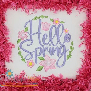 May include: Embroidered design with the text "Hello Spring" in purple script surrounded by a wreath of green leaves and pink flowers.