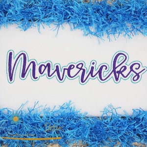 Può includere: Testo ricamato in viola e turchese su uno sfondo bianco che recita "Mavericks". Lo sfondo è circondato da un bordo soffice blu.
