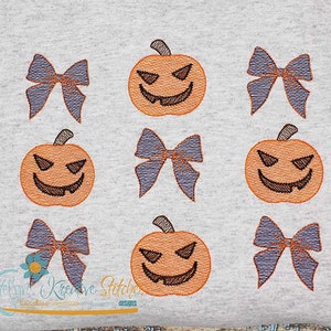 Könnte beinhalten: Ein grauer Hintergrund mit neun gestickten Bildern. Es gibt drei orangefarbene Jack-o'-Lantern-Kürbisse mit schwarzen Augen und einem zahnigen Grinsen. Es gibt sechs lila Schleifen mit einer weißen Mitte.