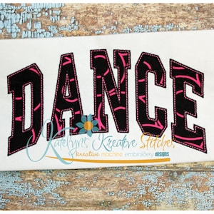 May include: Black and pink "DANCE" embroidery design with a swirling pattern inside the letters.