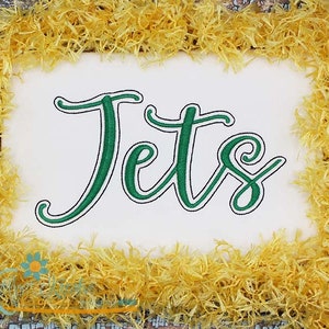 May include: Green embroidered cursive text that reads "Jets" on a white background. The text is surrounded by a yellow fluffy border.