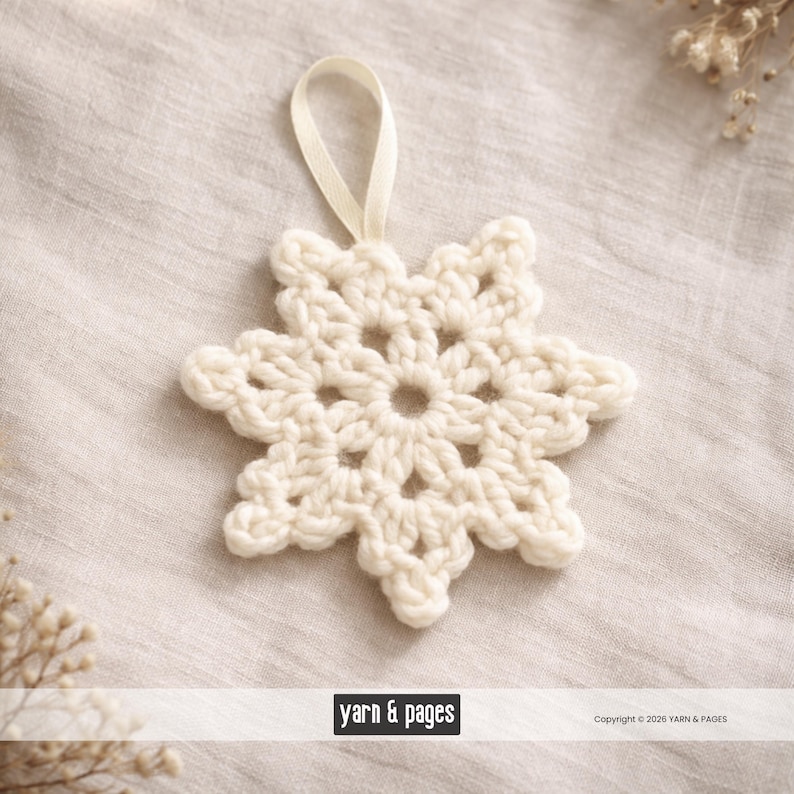 May include: A cream-colored, crocheted snowflake ornament with a loop for hanging. The snowflake has a detailed, openwork design and is made of a soft, textured yarn. The background is a neutral linen fabric, creating a cozy, wintery feel.