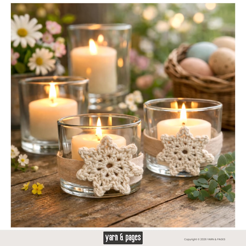 May include: Several lit candles in clear glass holders. Two holders have beige crocheted snowflake accents and burlap ribbon. The candles are on a wooden surface, with flowers and a basket of eggs in the background. The image has a warm, inviting feel.