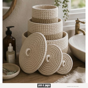May include: A set of four cream-colored crochet baskets with a tan stripe, stacked on a wooden surface. Three matching crochet lids are in front of the baskets. The baskets are in a bathroom setting.