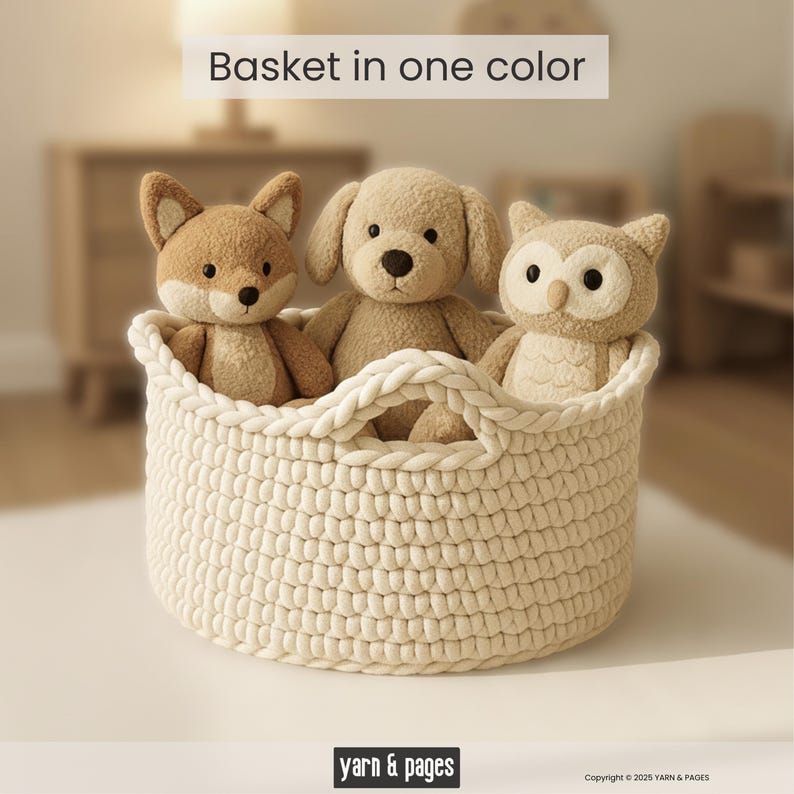 Puede incluir: Una cesta tejida de color crema contiene tres juguetes de peluche: un zorro, un perro y un b&uacute;ho. La cesta tiene dos asas y el texto "Basket in one color" est&aacute; encima de la cesta. La parte inferior de la imagen tiene el texto "yarn & pages".