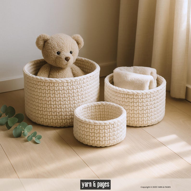 Puede incluir: Tres cestas de almacenamiento de color crema, tejidas a ganchillo, de varios tama&ntilde;os. La cesta m&aacute;s grande contiene un oso de peluche, y la cesta del medio est&aacute; vac&iacute;a. La cesta m&aacute;s peque&ntilde;a est&aacute; en primer plano. Las cestas est&aacute;n sobre un suelo de madera clara.