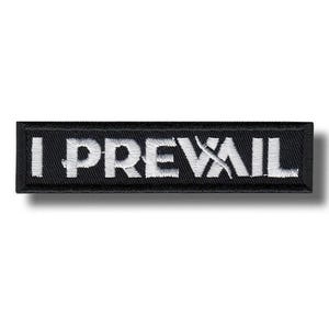以下が含まれることがあります： 「I PREVAIL」の文字が白で刺繍された黒い長方形のパッチ。パッチには白い縁取りがあります。テキストは太字のサンセリフ体です。パッチはおそらく布製です。