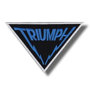 Könnte beinhalten: Ein schwarzer, dreieckiger Aufnäher mit dem Wort "TRIUMPH" in Blau, weiß umrandet. Der Aufnäher hat blaue Blitzdesigns und einen weißen Rand. Dieser Aufnäher ist wahrscheinlich für einen Motorrad- oder Automobil-Enthusiasten.