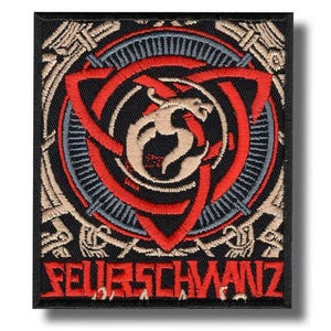 Puede incluir: Parche bordado con borde negro que presenta un diseño rojo, negro y beige. El diseño incluye un dragón estilizado dentro de un triángulo rojo y un patrón circular. El texto "FEUERSCHWANZ" está en la parte inferior.